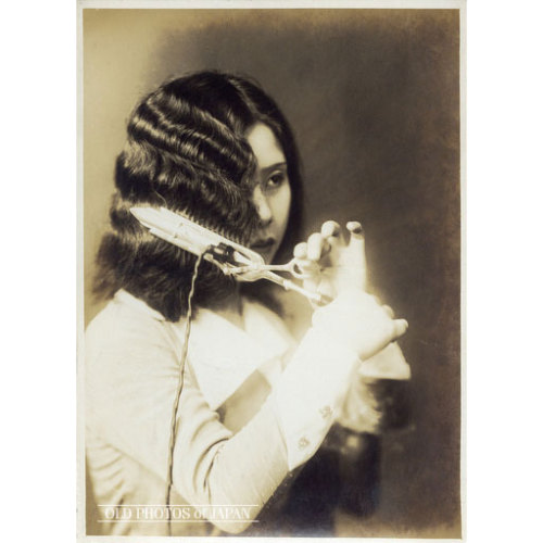 Young woman in the 1920s using an electric tool to create those iconic finger waves. Amazing. Credit