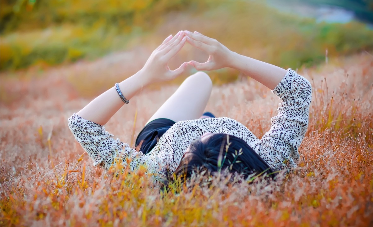 中華文化 草地上平躺的美女爱心手势4k壁纸