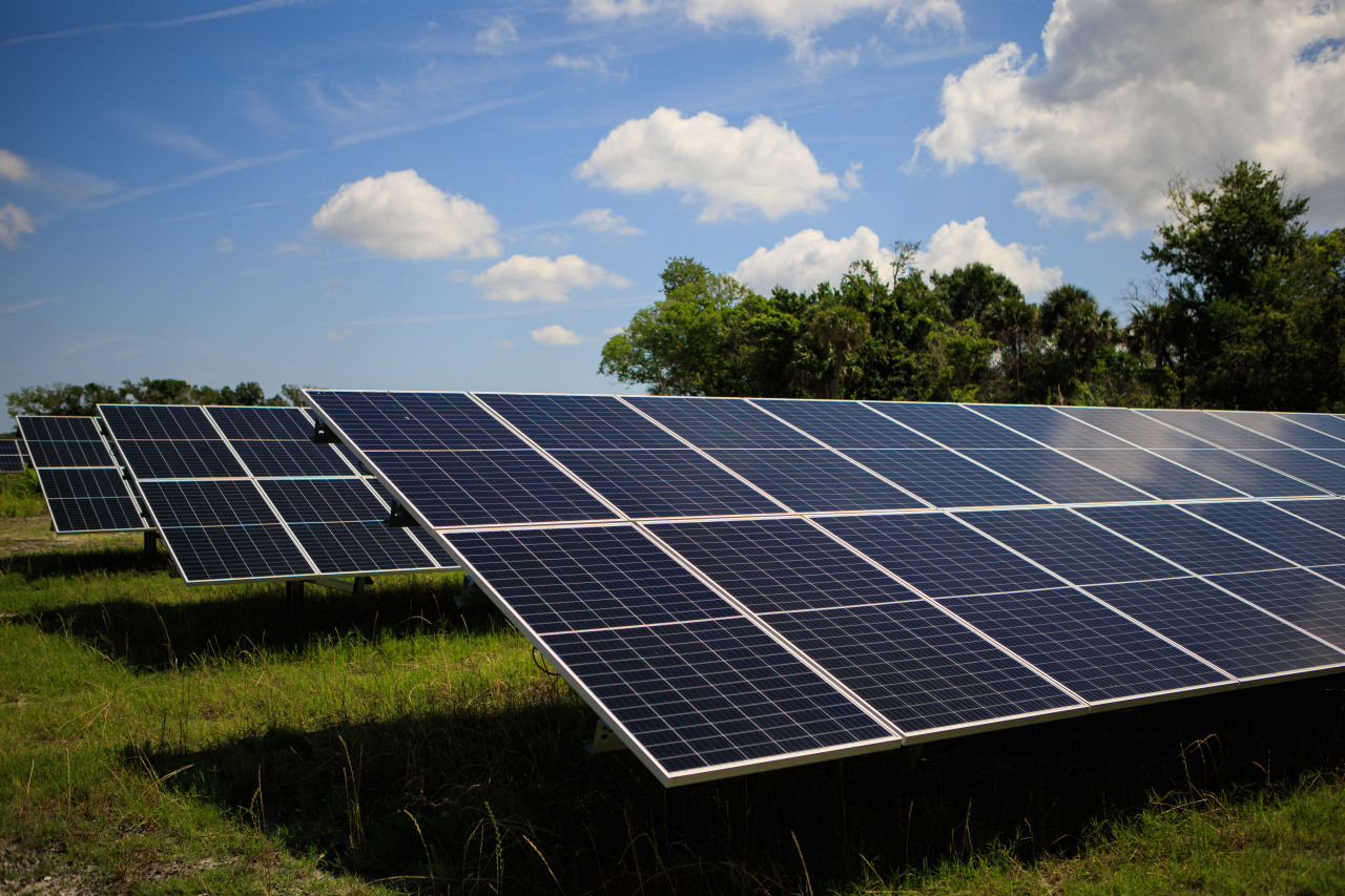 Three rows of solar panels stand at an angle in a grassy field at NASA's Kennedy Space Center in Florida. The sky is bright blue. Credit: NASA/Frank Michaux
