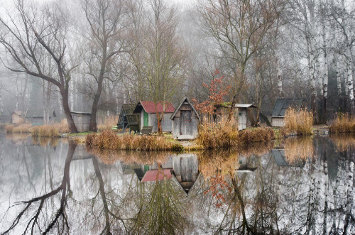 landscape-photo-graphy:Abandoned Fishing Village Outside of Budapest is Perfectly Reflected on the Lake by Viktor Egyed A few miles outside of Budapest lays a small abandoned fishing village composed of rustic huts, tall trees and an obscure atmosphere.