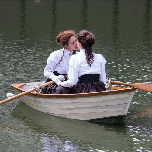 ailichi:On Lakeside Terrace at the Barbican in London, two women in Edwardian costume row a boat emb