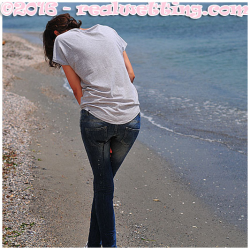 Walking on the beach, she lost control, pissing her tight jeans and sneakers.
