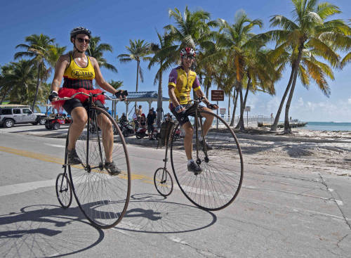 Amy Oleynik, left, and her father Randy Oleynik, right, ride on 132-year-old antique penny-farthing 