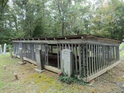 sixpenceee:  This grave house in southern Kentucky’s Muhlenberg County has a shed-style roof and the tombstones are placed outside, demonstrating that the main concern here is protecting the grave rather than the stone.