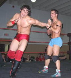 curioustj:  arcticboxing:  hot pro agony  By the looks of the “stiffie” packed in the blue trunks, I think there may be some “after match” festivities for these two hunks. Love the flopsy, mop-head hair on the red trunks boy.  I hope guy in blue