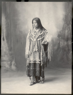 centuriespast:  Full length studio portrait of delegate Hattie Tom, a young Chiricahua Apache woman, wearing a fringed hide dress decorated with beads and metal cone tinklers. Photographed at the U.S. Indian Congress of the Trans-Mississippi and Internati