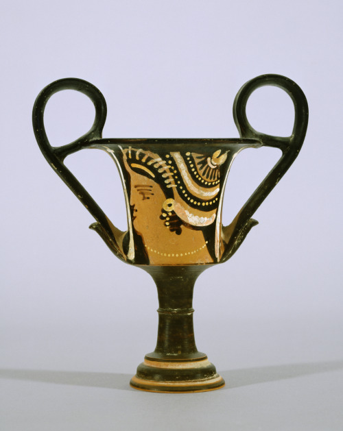 A red-figure kantharos (drinking cup) with a depiction of a woman&rsquo;s head.  Unknown ar