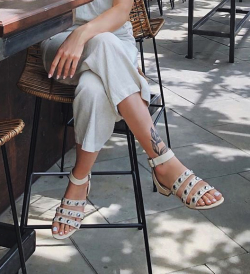 Banded studded sandals on pretty feet.