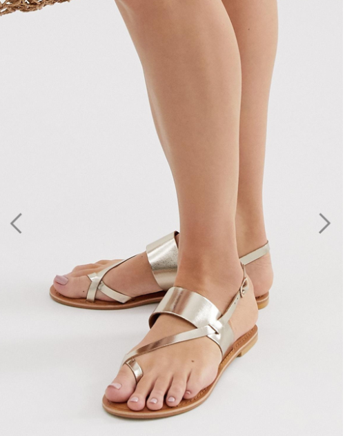 Beautiful gold toe cross sandals on pretty feet.