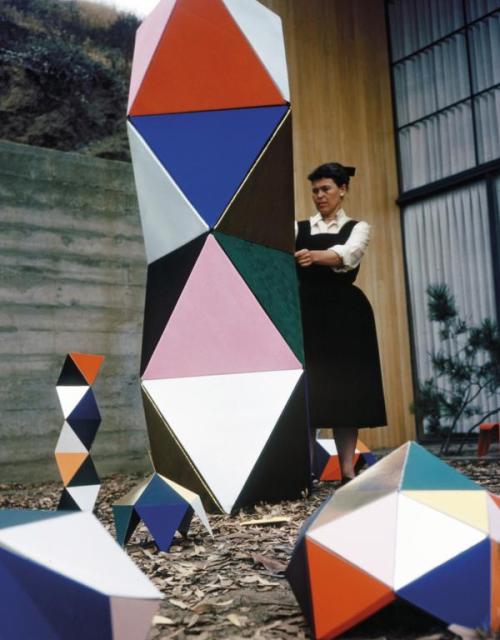 Ray Eames, in front of her house, holding a prototype of “The Toy”, a set of geometric p