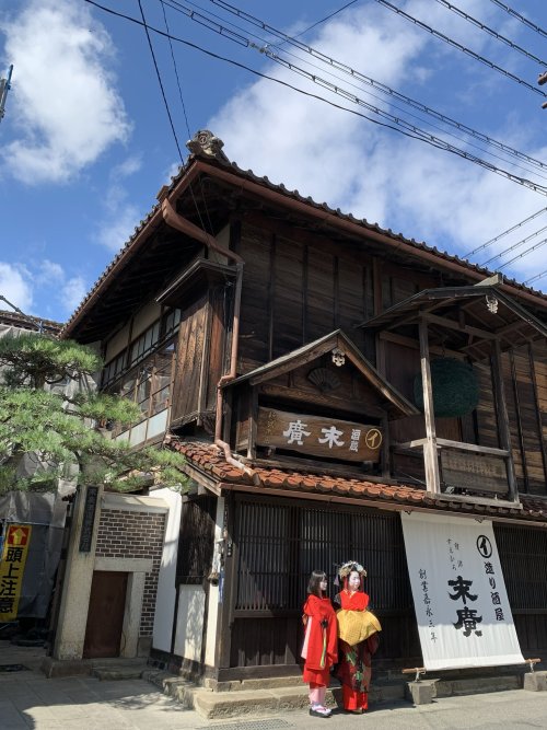 September 2021: Aoi-tayuu, of Suehiro okiya, and her kamuro pose in front of Suehiro Sake Brewery (n