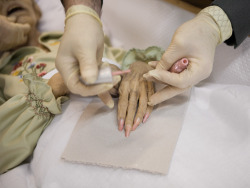 brokedownroadtrip:  sixpenceee:  The corpse of an elderly woman getting her nails painted in a pretty baby pink color in preparation for her funeral after already being embalmed. Photography credit to Patrik Budenz.  Creepy and adorable