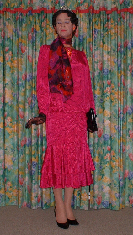 A lovely pink satin dress with flounced skirt. Lacy gloves a black handbag and shoes diamante jewell