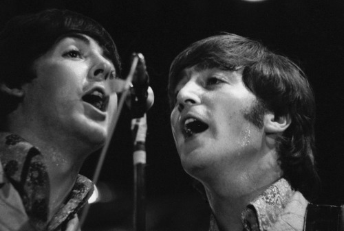 chaotichedonist:Paul McCartney and John Lennon of The Beatles share a mic during a concert at the Ri