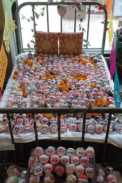 This ofrenda was constructed in remembrance of women killed along the Texas/Mexico border. I believe there is one sugar skull for every women who has been found dead. The symbolism is strong, powerful and controversial. Each skull has the name of one