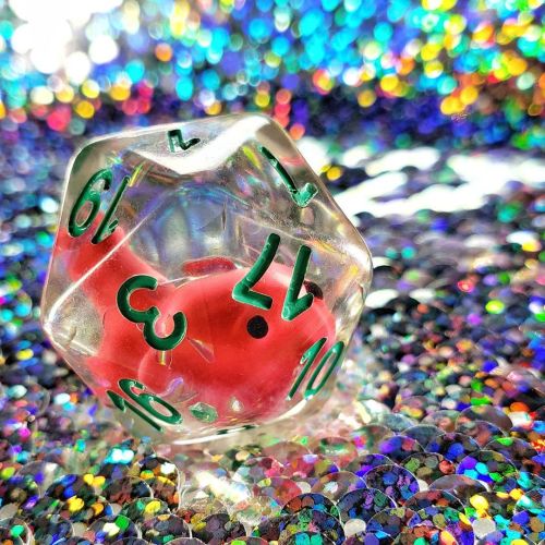 [Image description: A pink goldfish is suspended inside a clear d20 with teal font. It&rsquo;s surro