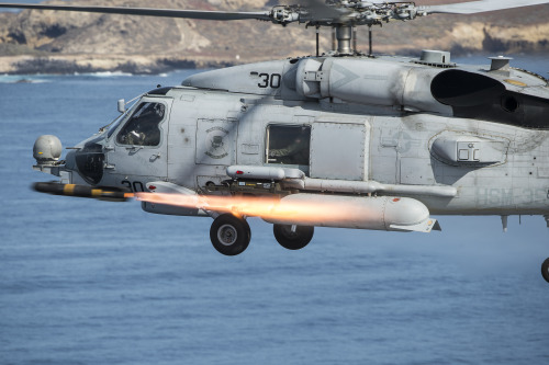 An MH-60R Seahawk helicopter, assigned to Helicopter Maritime Strike Squadron (HSM) 35, fires an AGM