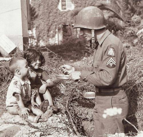 historicpicturess: 1943. This allied army soldier shares his food with these Italian children.