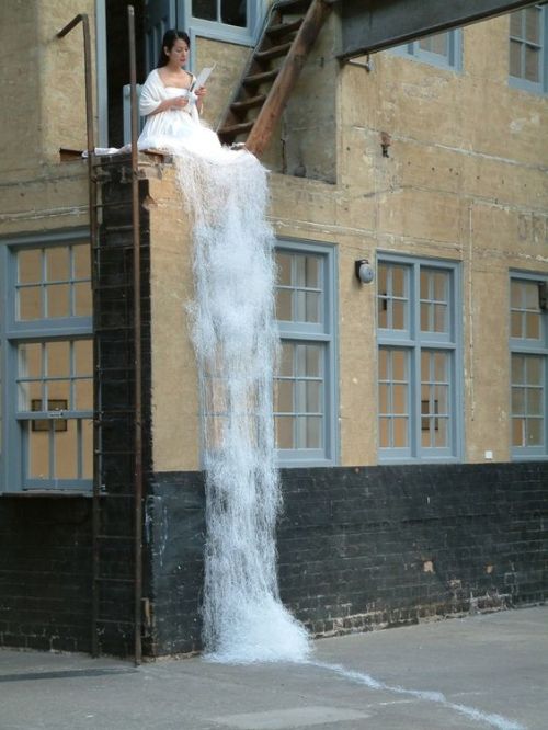 ollebosse:   Japanese artist Sachiko Abe sits atop a building in a white gown, cutting countless she