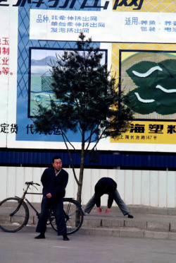 20aliens:  Shanghai, 1981. Two pedestrians halt for morning Tai Chi exercises on Shanghai street / Tokyo, 1984. Harajuku dance groups imitating American rock and roll on main street of neighbourhood closed only for dancing on Sundays. By Burt Glinn 