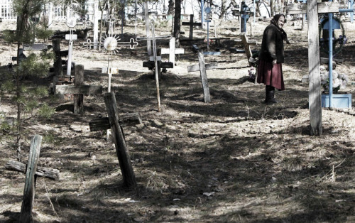 speciesbarocus:Anastasia Chekalovets stands in a cemetery near the village of Kopachi, which is with