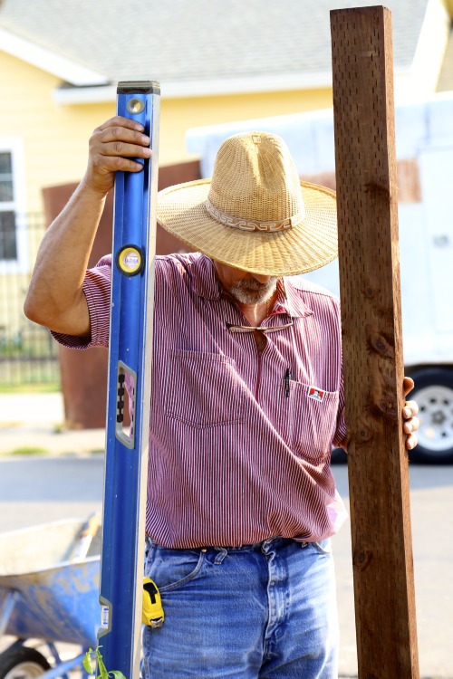 Level-Headed… A volunteer sets a fence post for a Paint the Town community service project sp