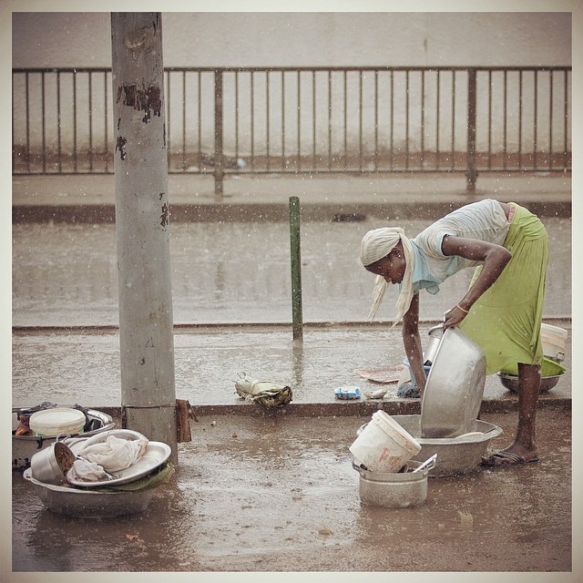 Rain water is free. Street food vendor washes her kitchen wares during a downpour. Accra, Ghana. Photo: Francis Kokoroko 2014 #rain #girl #wash #water