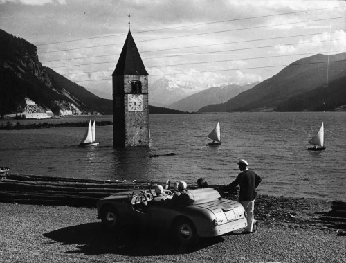 edoardojazzy:  Una macchina ferma davanti al campanile del lago di Resia (Bolzano), sotto al quale è sommerso il vecchio paesino di Curon, nell'agosto 1953A car stopped in front of the bell tower of Lake Resia (Bolzano), under which the old village of