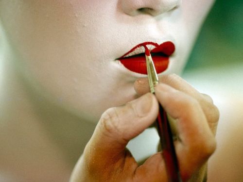 orux:A geisha in Kyoto, Japan, applies the blood-red lipstick that completes her traditional makeup.