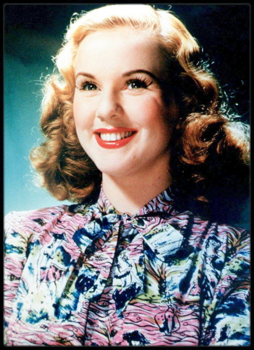 Deanna Durbin, Canadian actress and singer, smiling and wearing a short-sleeved patterned blouse in 