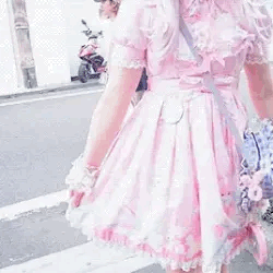 a person's outfit, consisting of a decorated, frilly pink dress being shown off to a camera and looked up and down