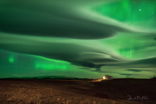 Aurora over Clouds : Auroras usually occur high above the clouds. The auroral glow is created when f