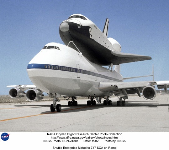 “Space shuttle Discovery is lowered onto the Shuttle Carrier Aircraft in the mate-demate