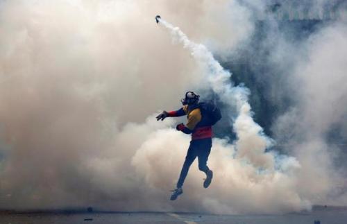 An opposition supporter clashes with riot police during a rally against President Nicolas Maduro in 