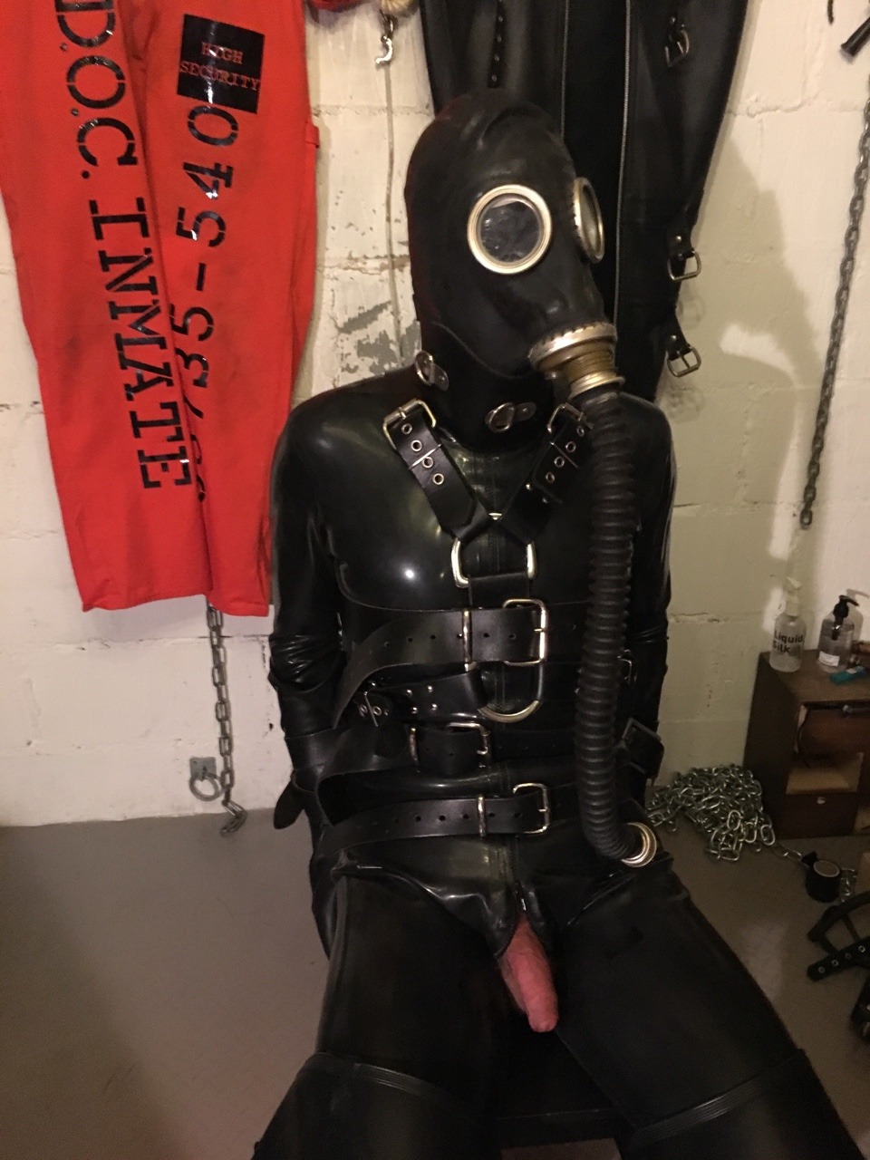 jamesbondagesx:  Rubber gimp strapped to chair, gagged, head mummified, gas masked