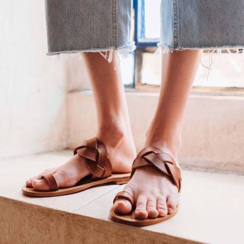 Braided leather toe ring sandals on pretty feet.