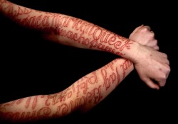 temporarilyeuropean:  After a performance wherein audience members were invited to write hurtful words they had been called on her body in marker, Coble took the most commonly used ones and covered her body in them using an inkless tattoo technique. (via