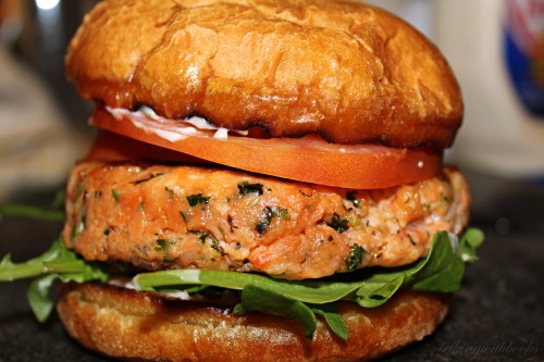 Lemon & Herb Wild Salmon Burger With wild arugula, tomato, and a sweet chili & roasted red p