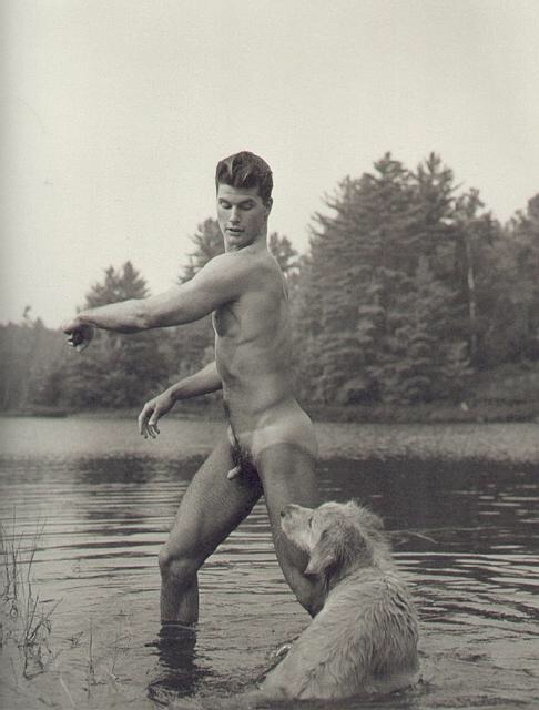 a muscular small endowed man with his dog.