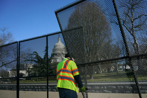 ccd-62:the-daily-tizzy: A worker putting up security fencing around the Capitol yesterday…Hmmmm…   N