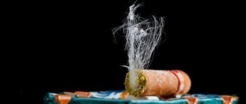 Cannoli dressed as a cigar with spun sugar as smoke and pistachio crum for ash. Complete with an Ita