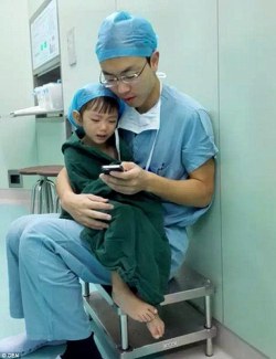 sixpenceee:  A cardiac surgeon comforts a weeping 2-year-old girl by playing cartoons before her surgery. This heart-warming scene was captured on September 18 at a hospital in Zhejiang, eastern China, reported People’s Daily Online. (Source) 