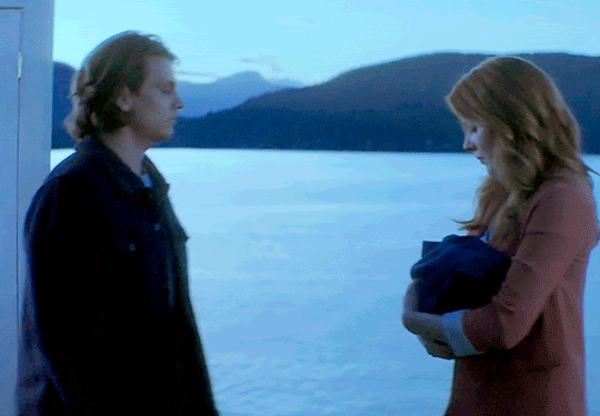 GIF FROM EPISODE 2X18 OF NANCY DREW. NANCY AND ACE WALK TOWARDS EACH OTHER AT THE BLUFFS. WHEN THEY MEET, NANCY STARTS TO PLACE THE BABY IN HER ARMS INTO ACE'S.