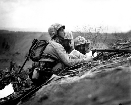 A team of Marine forward observers direct artillery and mortar strikes against Japanese positions on