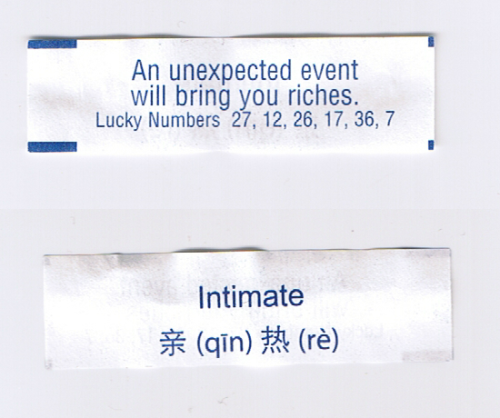 [A White Fortune Cookie Paper With Blue Text. Front: An Unexpected Event Will Bring You Riches. Lucky