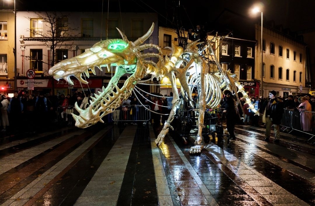 photo of a giant skeletal dragon puppet in a parade in a city at night