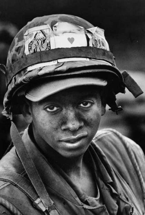 Pfc. John L. Lewis decorates his helmet with good luck tokens in Khe Sanh (Vietnam, February 1968). 