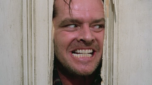the-overlook-hotel:  Filming jack Nicholson’s iconic “Here’s Johnny!” moment on the set of The Shining. The camera has been heavily protected from Jack’s axe and the debris which resulted from hacking open the door. 