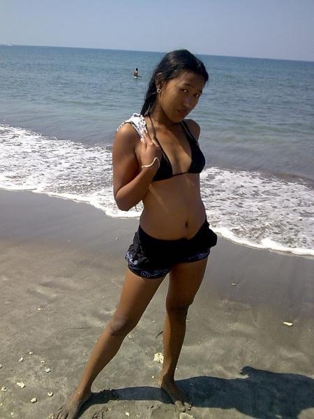 Having fun on the beach in the Philippines. Surfer girl in hot pants at Iba, Zambales. The sand is d