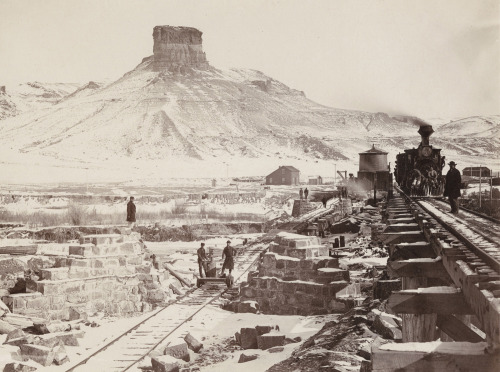 Construction of a railroad bridge in Green River Valley, Wyoming with Citadel Rock in the background